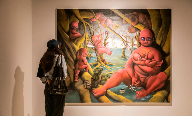 Mujer observando un cuadro en una exposición de arte