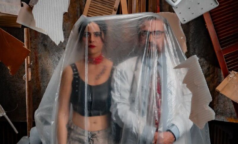 una pareja elegante detrás de un plástico transparente