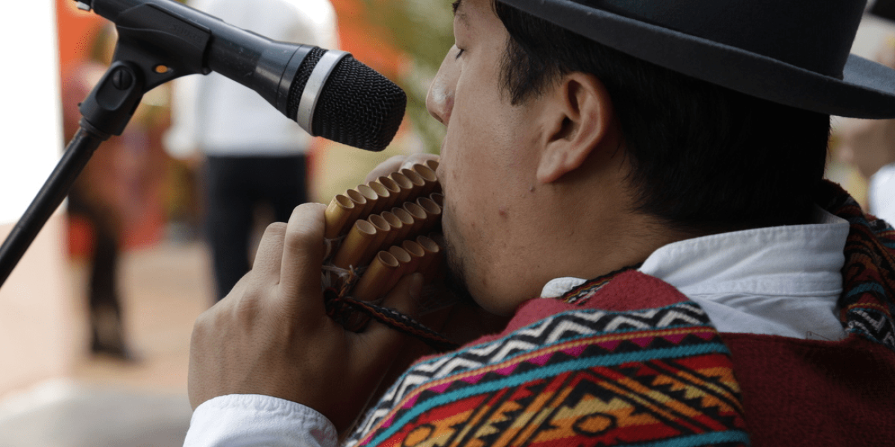 Hombre indígena tocando instrumento de viento