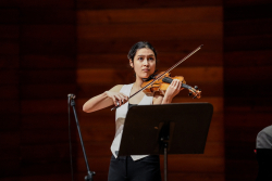 Música interpretando el violín en un teatro