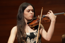 Música interpretando el violín en un teatro