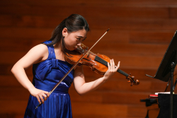 Música interpretando el violín en un teatro