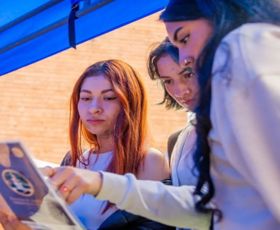 Tres mujeres revisando un libro