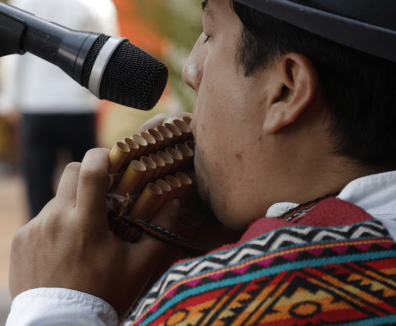 Hombre indígena tocando instrumento de viento