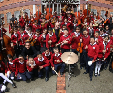 Foto de la Filarmónica en un colegio de Bogotá y sus alumnos