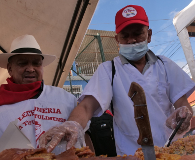 personas vendiendo lechona