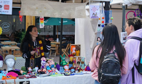 Emprendedora hablando con dos compradores en una feria en los Distritos Creativos