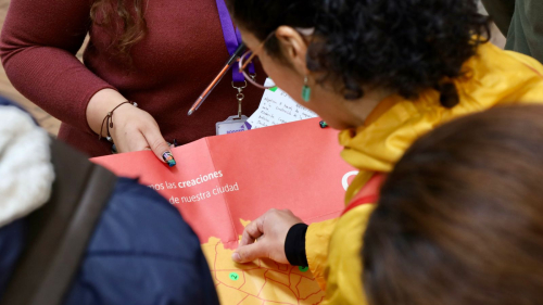 Mujer poniendo un sticker en mapa de Bogotá