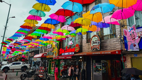 Calle de lechonerías decorada con sombrillas de colores