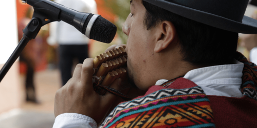 Hombre indígena tocando instrumento de viento
