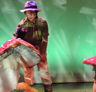 mujer con títeres de hongos gigantes