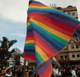 Marcha con la bandera LGBTI en primer plano